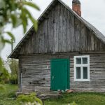 brown wooden house on green grass field during daytime