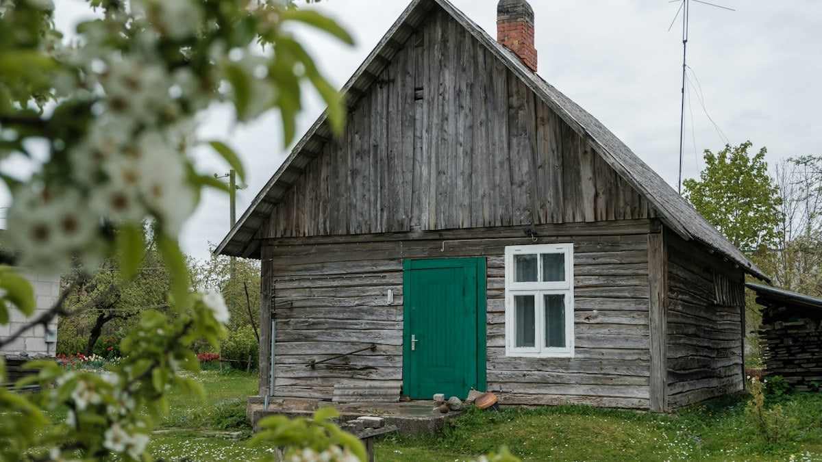 brown wooden house on green grass field during daytime