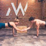 Fit couple working out together in a modern gym, showcasing teamwork and a healthy lifestyle.